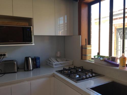 a kitchen with a stove and a microwave at Grannyflat in Bankstown