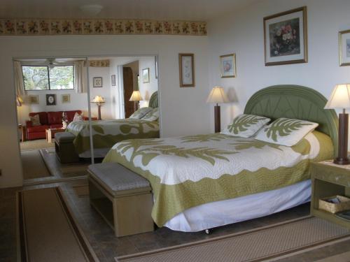 a bedroom with a large bed and a living room at Belle Vue Kona Inc in Captain Cook