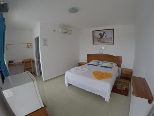 1 dormitorio con 1 cama en una habitación blanca en Stefany's Lodging, en Puerto Baquerizo Moreno