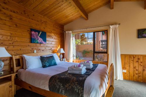 a bedroom with a bed and a window at Kimi Ora Eco Resort in Kaiteriteri