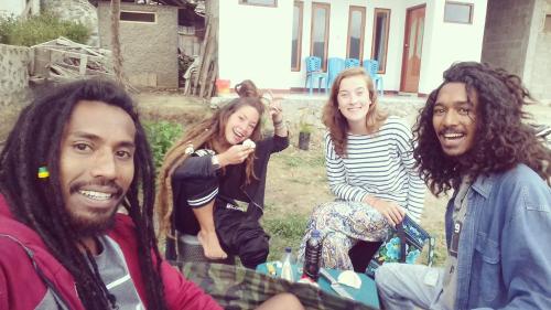 a group of people sitting around a table at Mahoni Guest House in Kelimutu