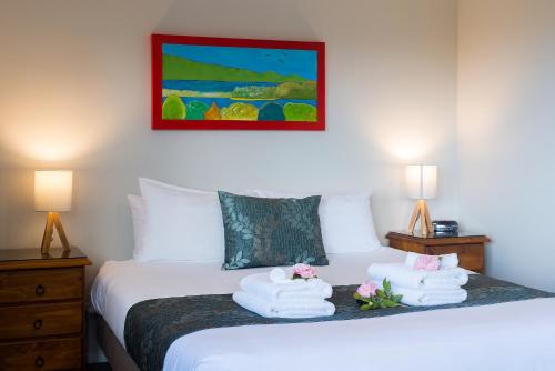 a bedroom with a bed with towels on it at Kimi Ora Eco Resort in Kaiteriteri