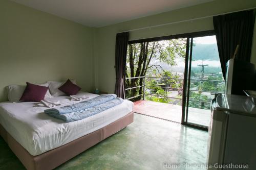 a bedroom with a bed and a large sliding glass door at Home Phang-Nga Guesthouse in Phangnga