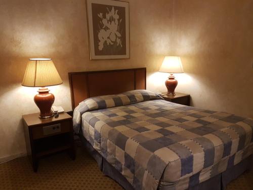 a hotel room with a bed and two lamps on tables at Petra Palace Hotel in Wadi Musa