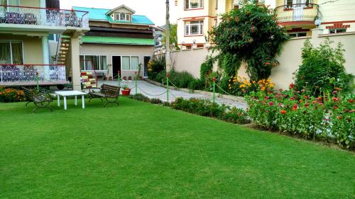 a garden with a table and benches in a yard at Ikraam Inn Bed & Breakfast in Srinagar