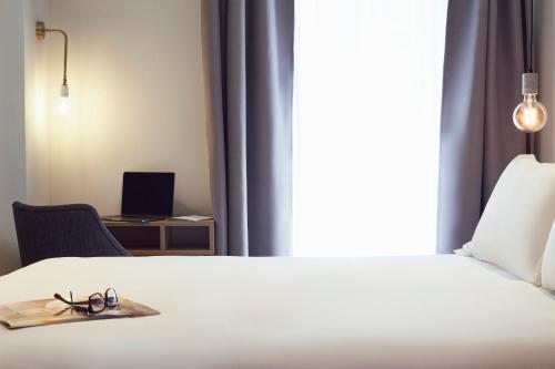 a bedroom with a bed with a pair of glasses on it at Hôtel Maison Montgrand - Vieux Port in Marseille