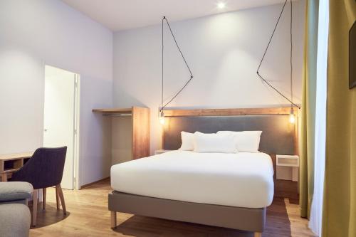 a bedroom with a white bed and a chair at Hôtel Maison Montgrand - Vieux Port in Marseille