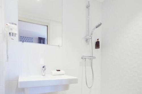 a white bathroom with a sink and a shower at Hôtel Maison Montgrand - Vieux Port in Marseille
