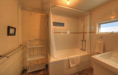 ein Bad mit einer Badewanne, einer Dusche und einem Waschbecken in der Unterkunft Stanley View Beach House in Stanley