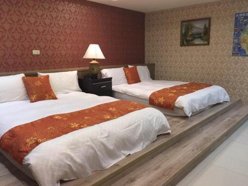 two beds in a hotel room with at Good Sleep B&B in Ruifang
