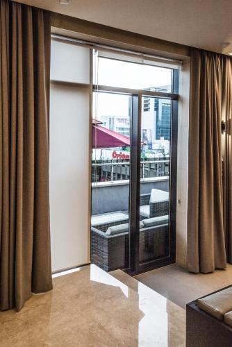 a room with a large glass door with a balcony at Rivertain Hotel in Daegu