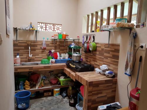 a kitchen with wooden walls and a counter top at Red Island Bungalows in Pasanggaran