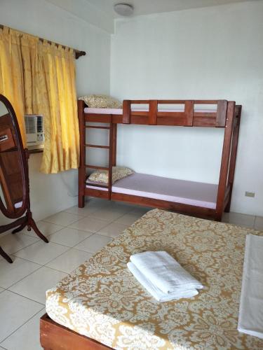 a room with two bunk beds and a rug at Anton's Beach Resort in Oslob
