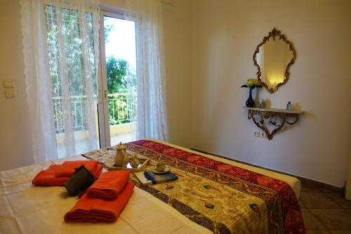 a bedroom with a bed with a mirror and a window at Maisonette Ilios in Korfos