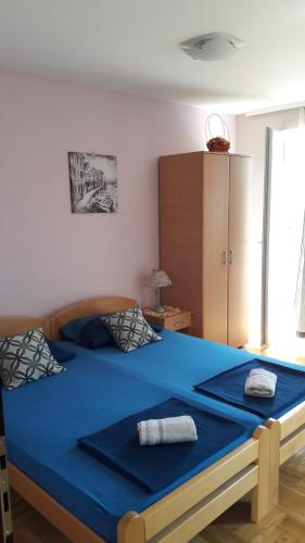 1 dormitorio con 1 cama grande con manta azul en Apartmani V&F, en Vrnjačka Banja