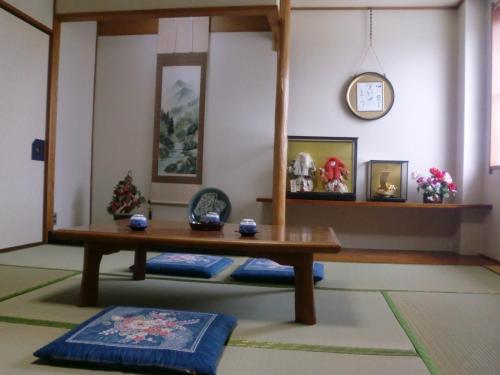 a living room with a table and a clock on the wall at Suzukisou in Kyoto