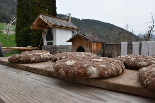 Eine Gruppe Brote liegt auf einem Holztisch in der Unterkunft Haflingerhof in Jenesien