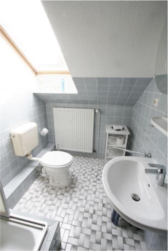 a bathroom with a white toilet and a sink at Haus Anker in Böhl