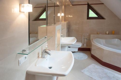 a bathroom with a sink and a toilet and a tub at Klimkówka 96 - Dom w górach nad jeziorem in Klimkówka