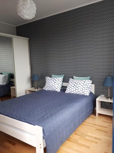 ビャウィストクにあるNova Apartamentのベッドルーム1室(大型ベッド1台、青いシーツ付)