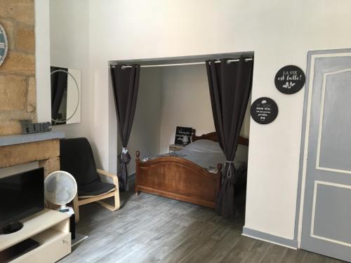 a bedroom with a bed and a tv and a mirror at L'instant Sarladais in Sarlat-la-Canéda