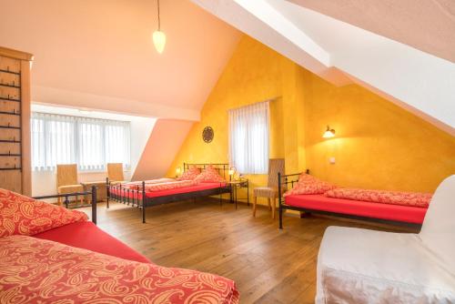 فندق أرندت غارني في روست: غرفه كبيره اثاث احمر وجدران صفراء