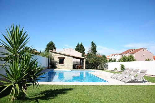 オ・グローベにあるCasa rural con piscina Viña de Millanのラウンジチェア2脚付きの庭のスイミングプールを利用できます。