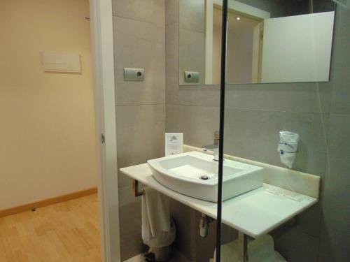 een badkamer met een wastafel en een spiegel bij Hotel Ortuella in Ortuella