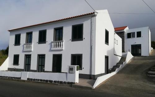 a white building with black windows and a street at BELO CAMPO - Ilha do Faial (Horta) in Castelo Branco