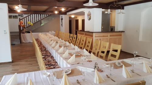 a long table in a room with chairs and glasses at Club Rezidence Pod Lučí in Loučovice