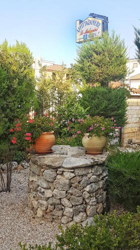 two vases sitting on top of a stone wall at Affittacamere La Madonnina in San Giovanni Rotondo