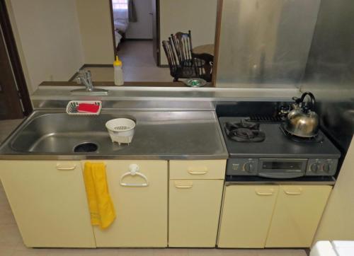 a kitchen with a sink and a stove at Frontier Sunrise in Kami-furano