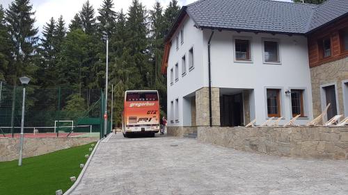 a double decker bus parked in front of a building at Club Rezidence Pod Lučí in Loučovice