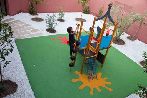 a child playing on a slide in a playground at Oliva Hotel Condominium Marrakech in Marrakech