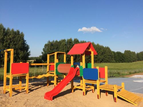 un parco giochi con sedie colorate e scivolo di WJM Jagodne Wielkie a Miłki