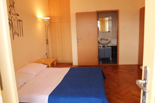 a bedroom with a bed and a bathroom with a sink at Apartment Dora in Crikvenica