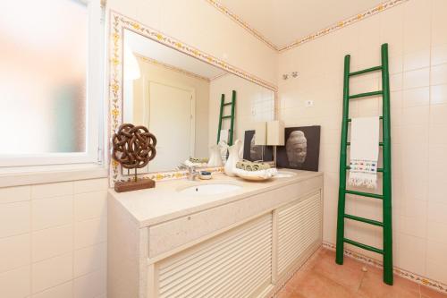uma casa de banho com um lavatório e um espelho em bwelcome aroeira beach & golf em Charneca
