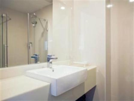 een badkamer met een witte wastafel en een spiegel bij Hotel S Damansara in Kuala Lumpur