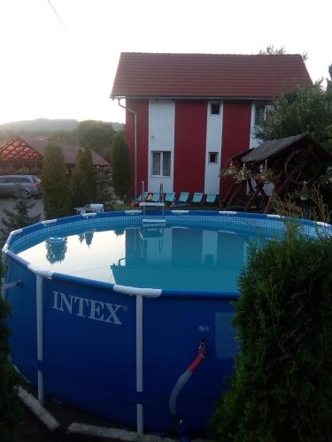 a swimming pool in front of a house at Pensiunea Robi&Norbi Sovata in Sovata