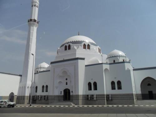 a white building with a mosque with a minaret at In Taibah in Al Madinah
