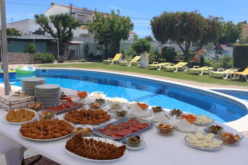 um buffet de comida numa mesa ao lado de uma piscina em Sunshine em Albufeira