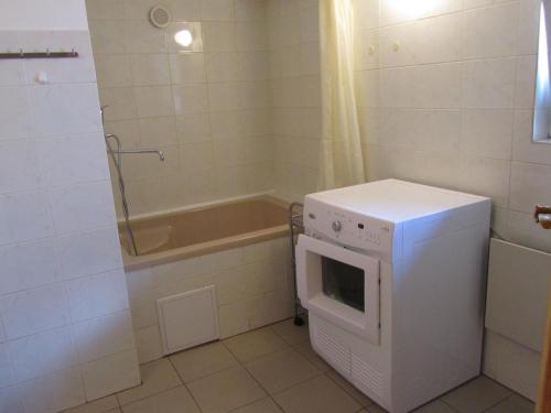a small bathroom with a microwave and a tub at Horská Chata U Básníka in Horní Malá Úpa