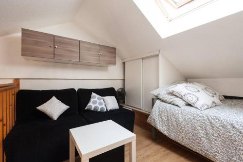 - un salon avec un canapé noir et un lit dans l'établissement Aoustin, à Nice