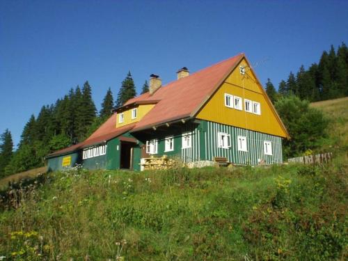 a large barn with a red roof on a hill at Horská Chata U Básníka in Horní Malá Úpa