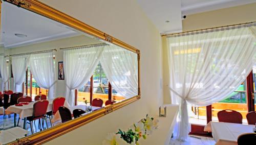 a mirror in a dining room with a table and chairs at Hotel Boruta in Zakopane