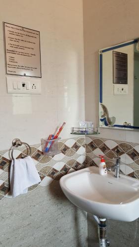 a bathroom with a sink and a mirror at Anand Agro Tourism Kashid in Alibaug