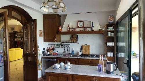 eine Küche mit Holzschränken und einer Arbeitsplatte in der Unterkunft B&B la taverna degli Angeli in Vezzi Portio