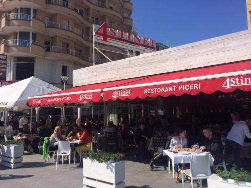 a group of people sitting at tables outside a restaurant at Hotel Lido in Durrës