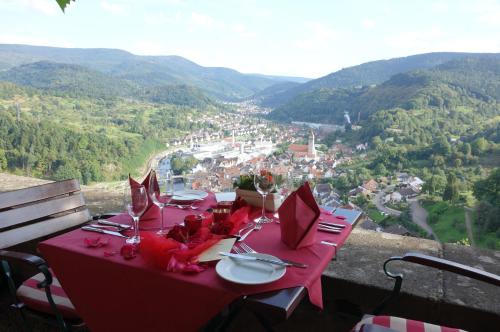 a table with a red table cloth on top of a mountain at Schloss Eberstein in Gernsbach