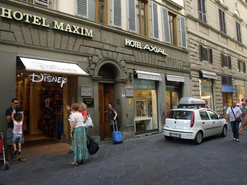 a group of people walking down a street in front of a store at Domus Duomo in Florence